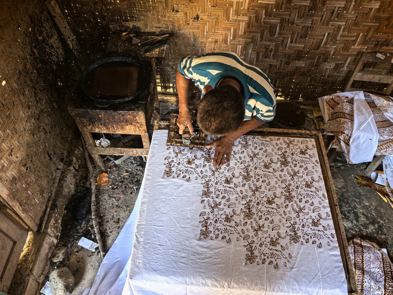 Proses tjap tradisional batik kopi oleh pengrajin senior