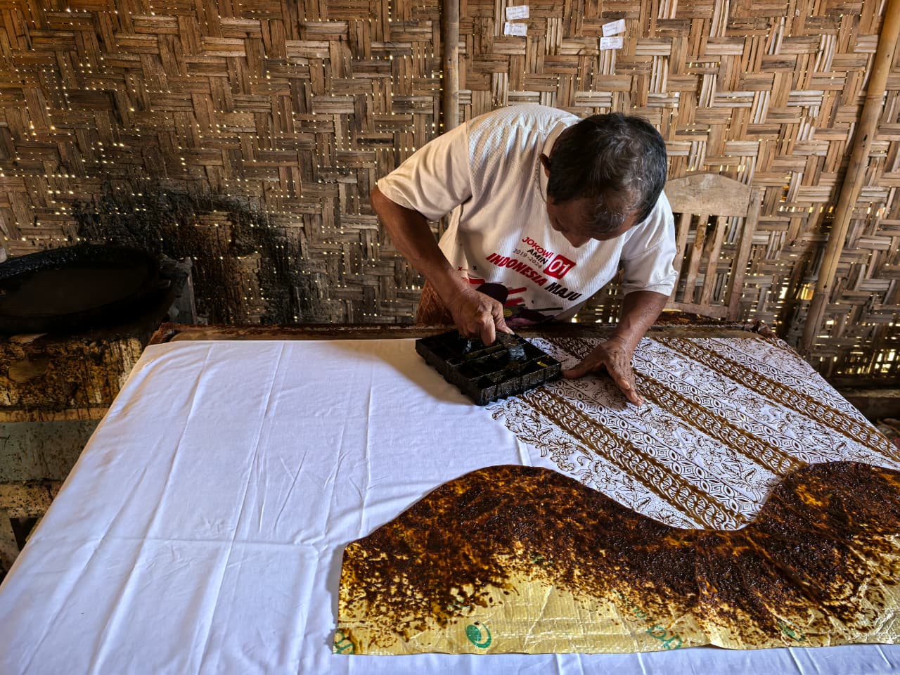 Artisan batik cap stamping dengan malam
