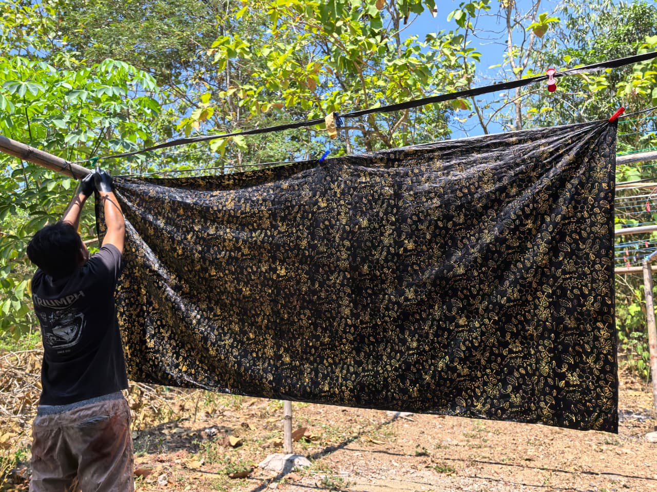 Kain batik kopi dikeringkan dijemur di bawah sinar matahari