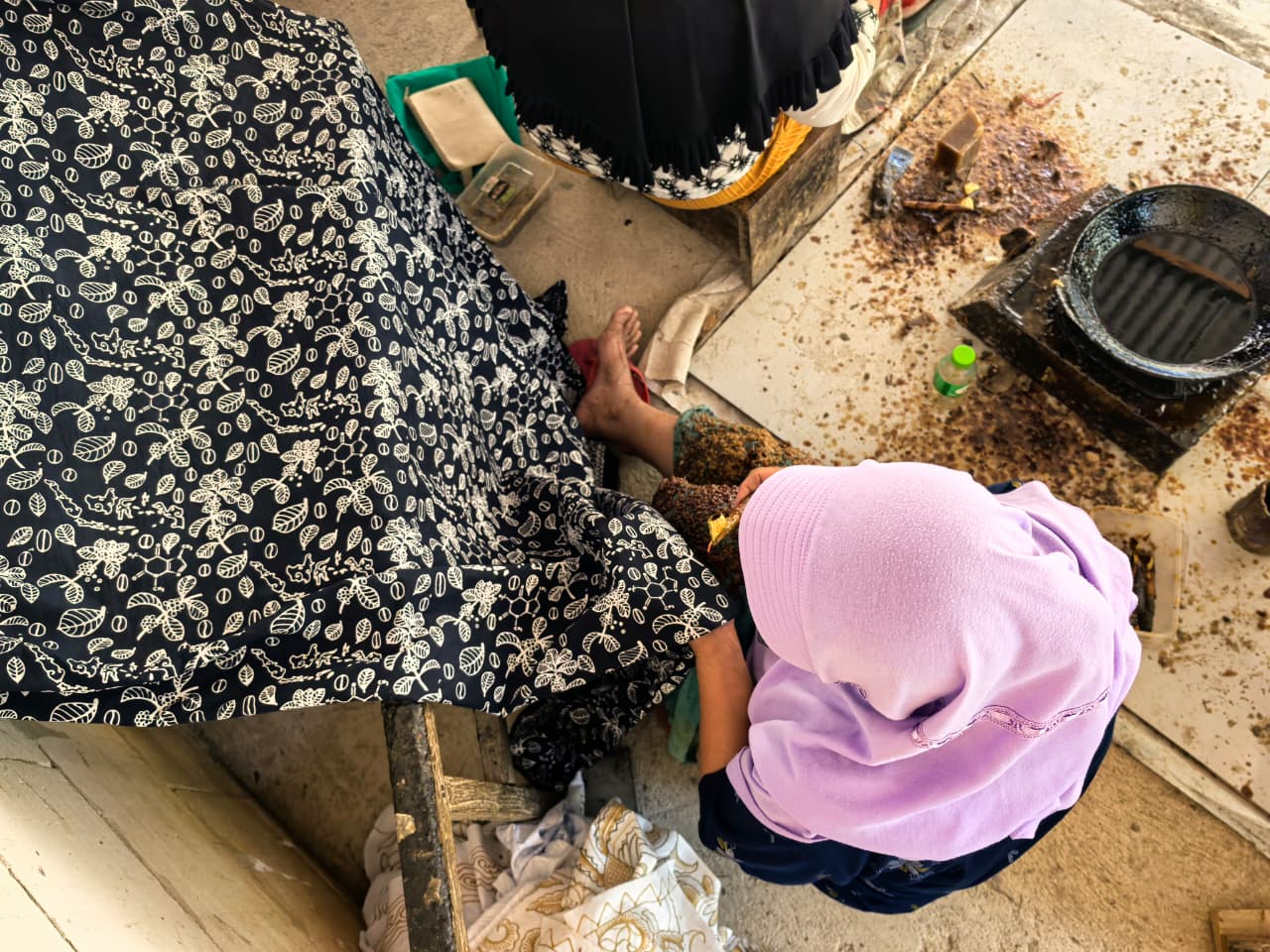 Artisan batik tulis menggunakan canting untuk motif tanaman kopi
