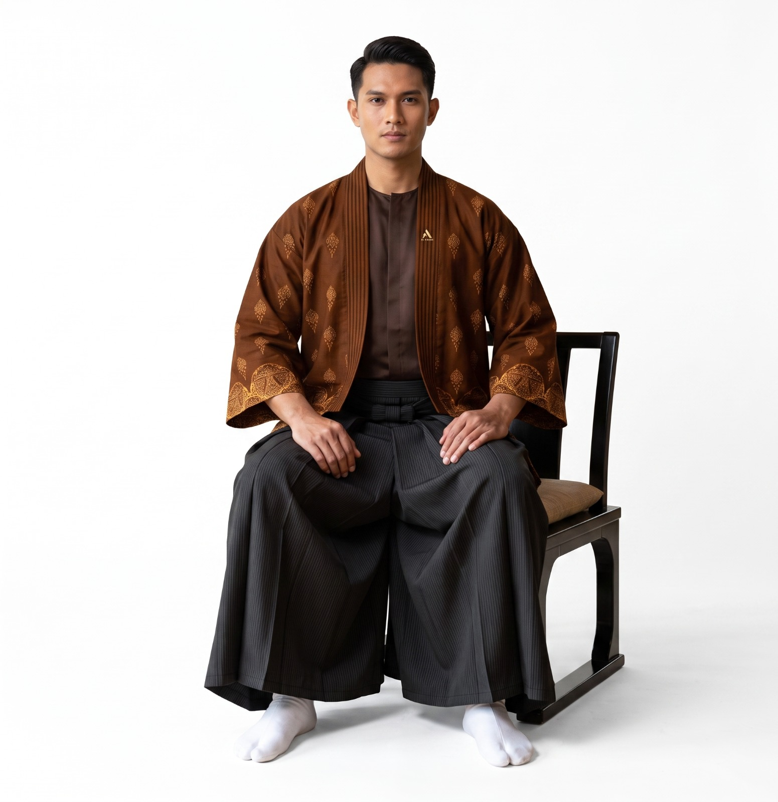 Model mengenakan batik kopi haori jacket dengan hakama dan tabi socks, duduk di kursi kayu